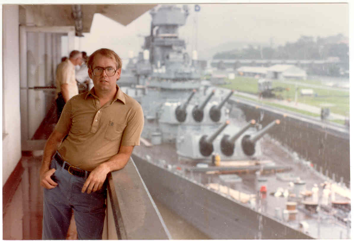 Jimmy Lee Slover at Miraflores Locks, Canal Zone, with USS New Jersey BB-62 in transit behind him, 1983