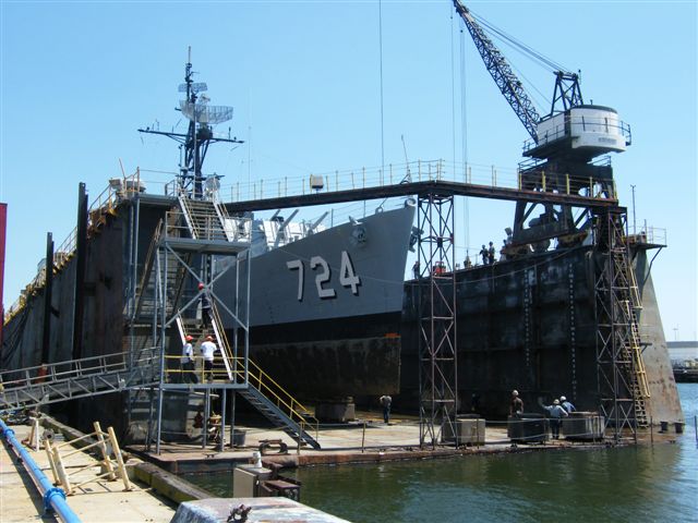 USS Laffey DD-724 in drydock — starboard quarter view showing the destroyer's hull plating stripped back for inspection and bottom replacement