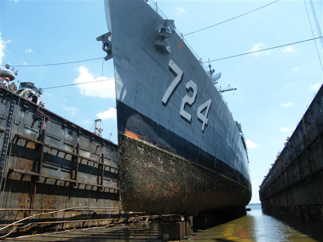 USS Laffey DD-724 drydock — workers and staging visible beneath the hull as steel bottom plates are prepared for replacement, Detyens Shipyard 2009