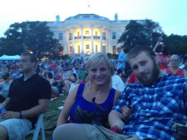 Taylor Morris and his girlfriend seated on the White House lawn at dusk among a Fourth of July crowd