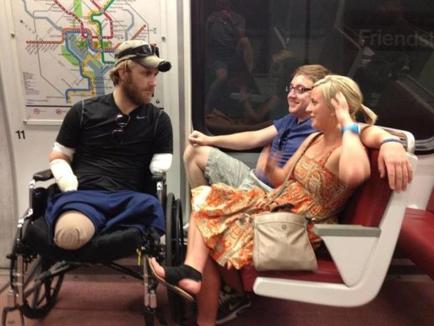 Taylor Morris riding the Washington Metro in his wheelchair, talking with friends across the aisle
