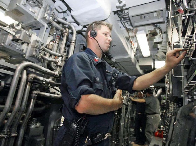 Officer on USS Texas testing torpedo tube with water